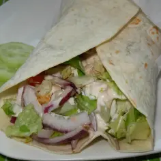 Pyszny kebab w tortilli z kurczakiem, sałatą, cebulą i sosem. Zastanawiasz się, ile waży kebab w tortilli? Ten wygląda na sycący!