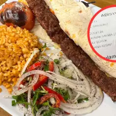 Prawdziwy turecki kebab: soczysty szaszłyk mięsa, ryż bulgur, pieczony pomidor i świeża sałatka z cebuli i papryki. Na rachunku widać nazwę "DANA KEBAP".