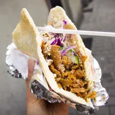 Pyszny kebab bez glutenu w bułce z mięsem, warzywami i sosem. Idealny na szybki posiłek.