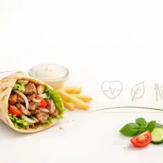 Kebab zawinięty w placek z frytkami, sosem i warzywami.
