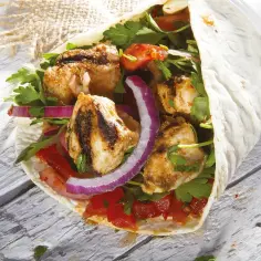 Pyszny wrap z grillowanym kurczakiem, pomidorami, czerwoną cebulą i pietruszką. To właśnie jest doner, co to znaczy – pyszne jedzenie!