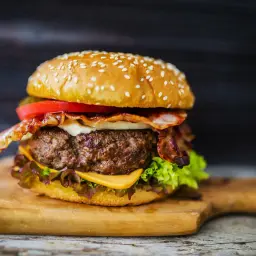 Soczysty burger wołowy z bekonem, serem i warzywami. Idealny przykład, jak przyprawić mięso wołowe na burgery, by były pyszne.
