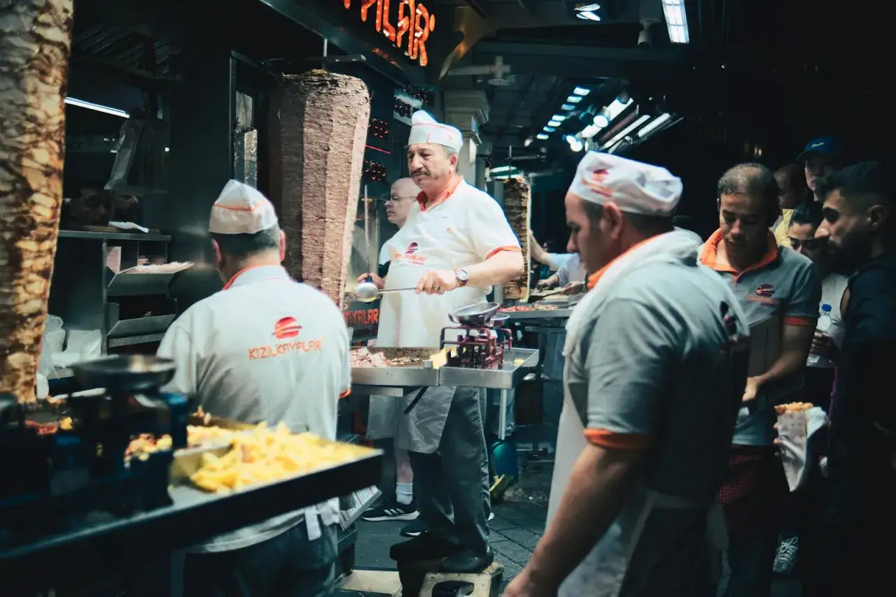 Sprzedawcy przygotowują kebaby, klienci czekają w kolejce. Zastanawiasz się, ile można zarobić na kebabie?
